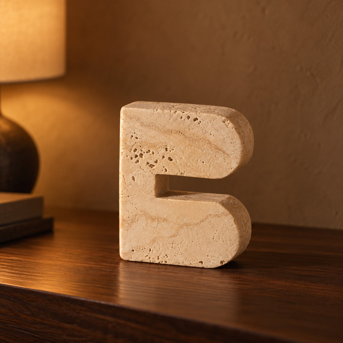 Beige travertine cave arch block ornament on a walnut shelf