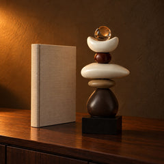 Cairn balance stones sculpture next to a hardcover book for size