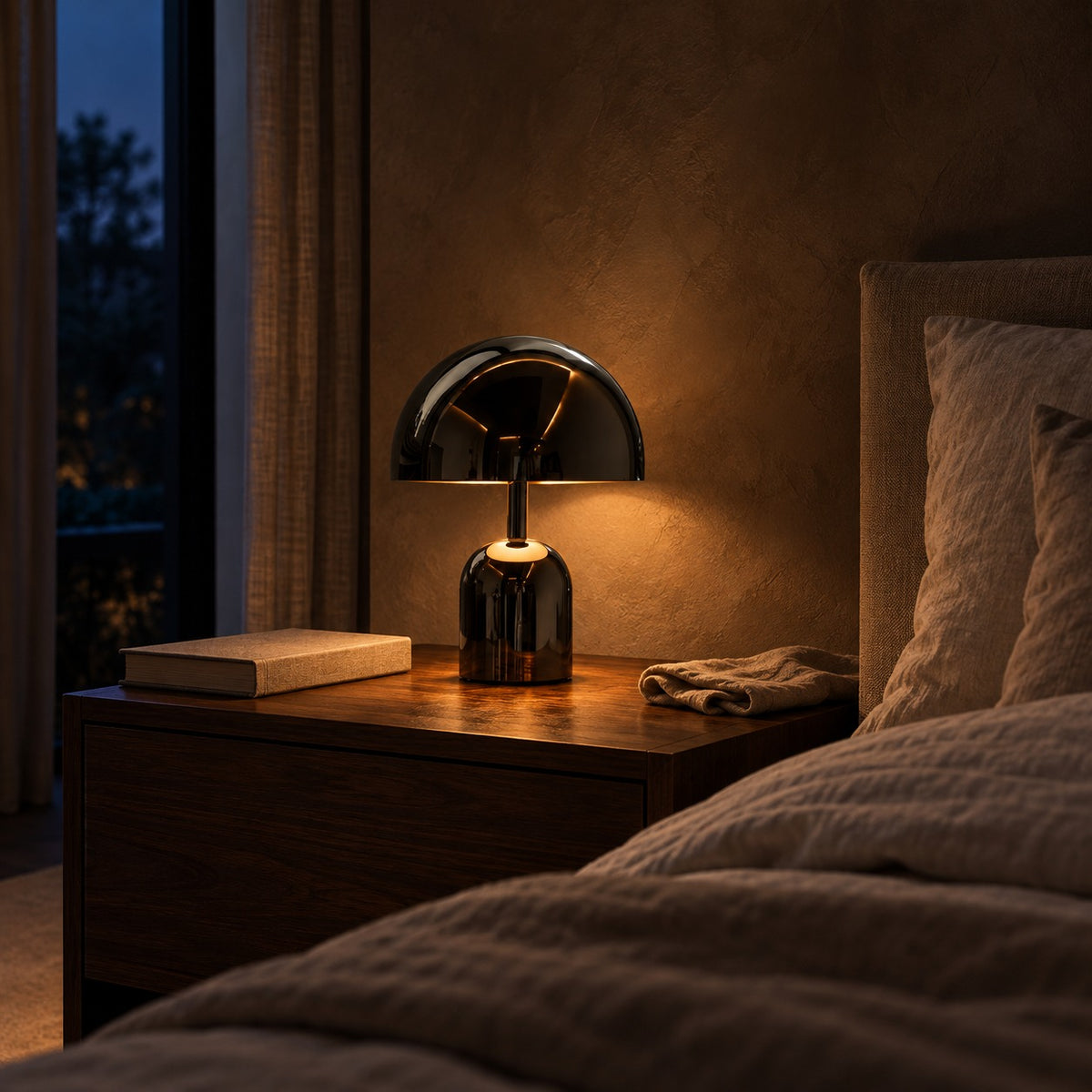 Kupol Mushroom Lamp lifestyle, glowing on a walnut bedside table at night