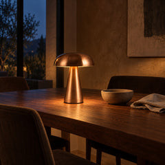 Spire Metal Table Lamp lifestyle, glowing on a walnut dining table at night