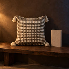 Tassel cushion next to a hardcover book for size