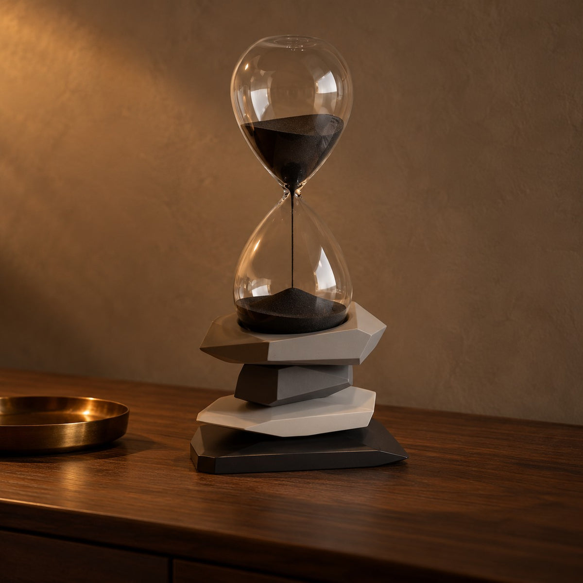 Cairn Hourglass Timer with charcoal stone base on a dark walnut console