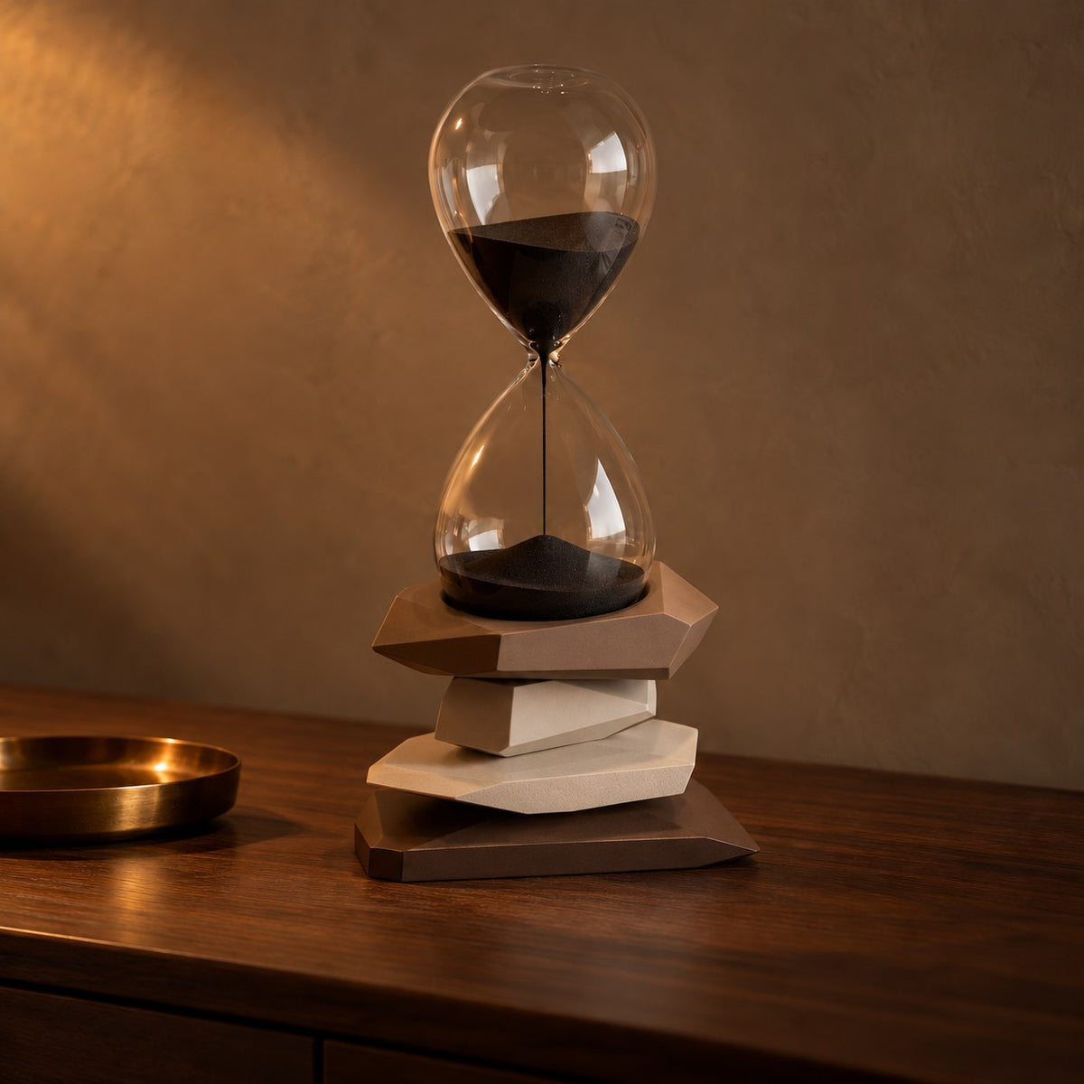 Cairn Hourglass Timer with brown stone base on a dark walnut console