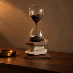 Cairn Hourglass Timer with brown stone base on a dark walnut console