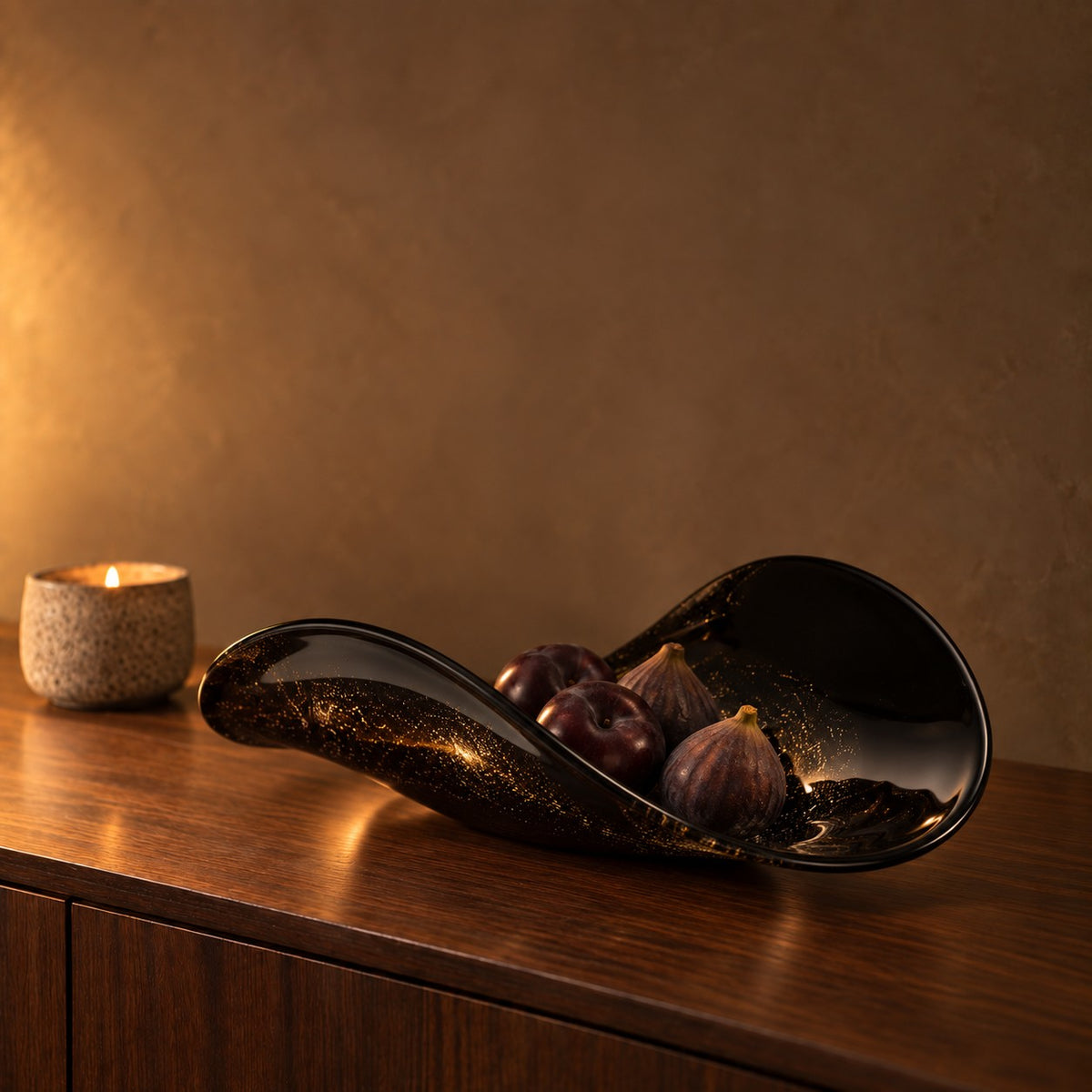 Noir Gilt black and gold glass bowl with figs on a walnut sideboard