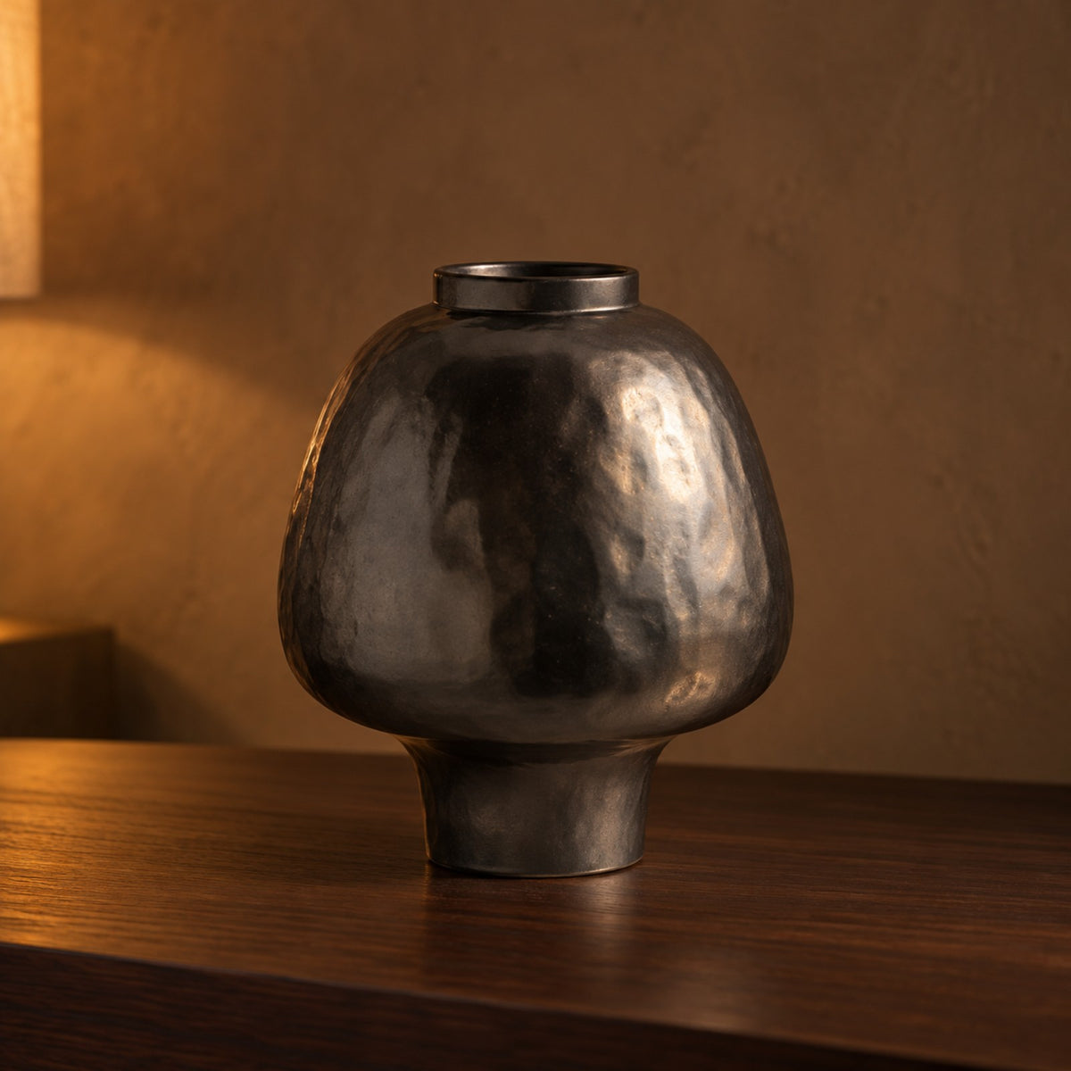 Hammered Black Ceramic Vase close up on a walnut console