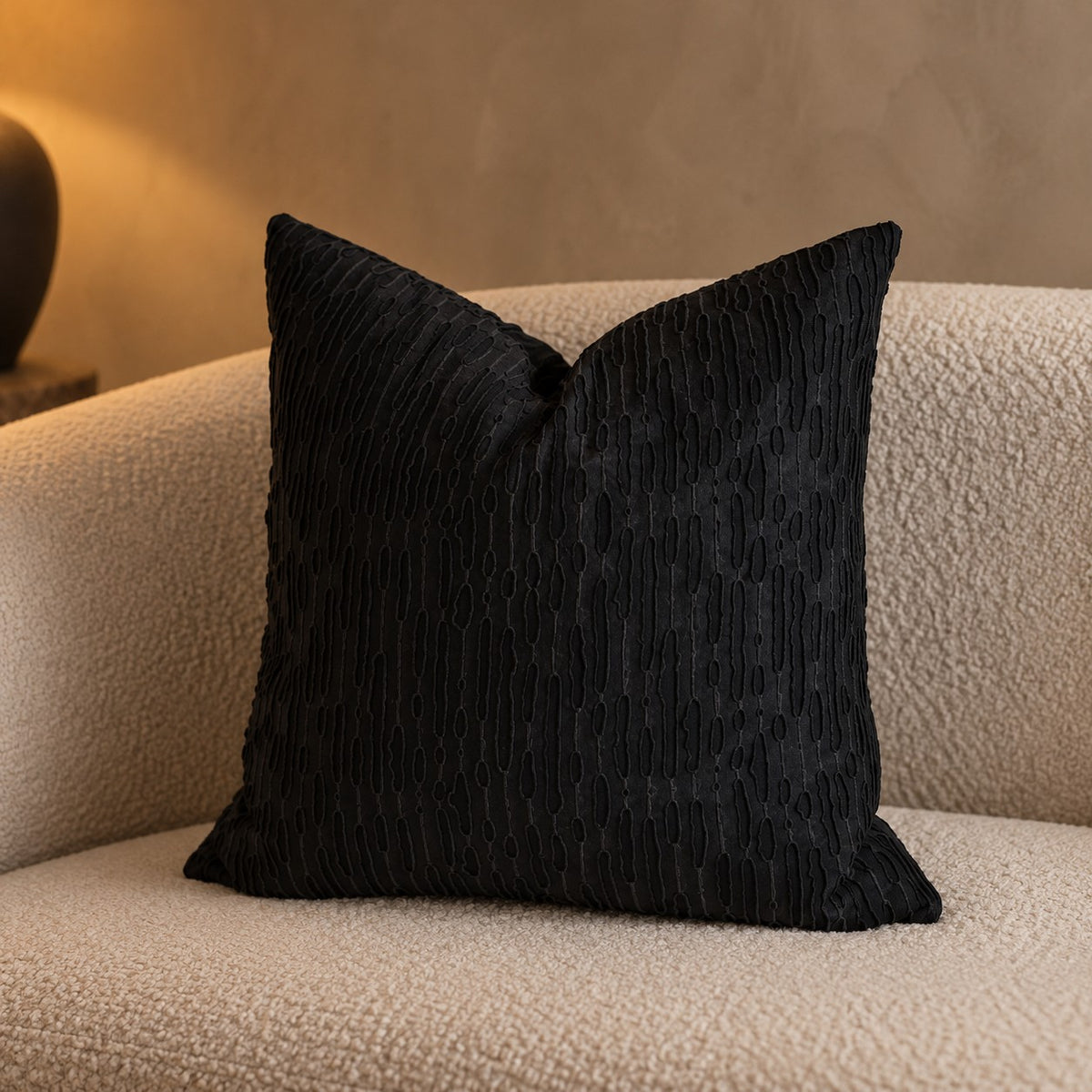 Ripple Textured Cushion in black on a boucle sofa