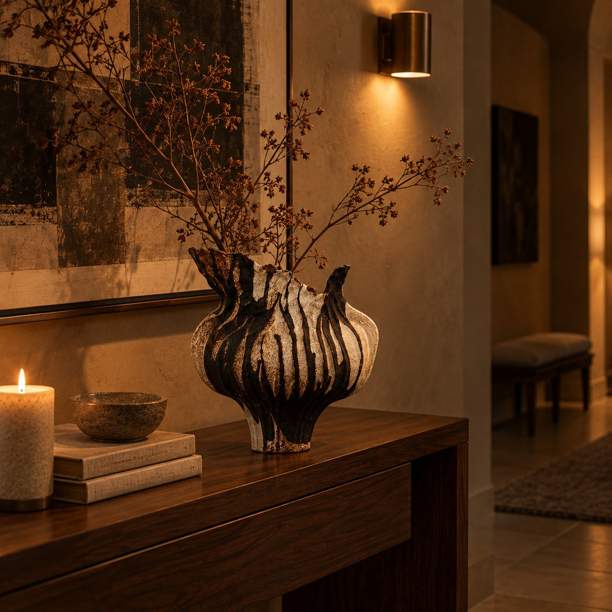 Umbra Drip Sculptural Vase with dried branches in an entry hall at night